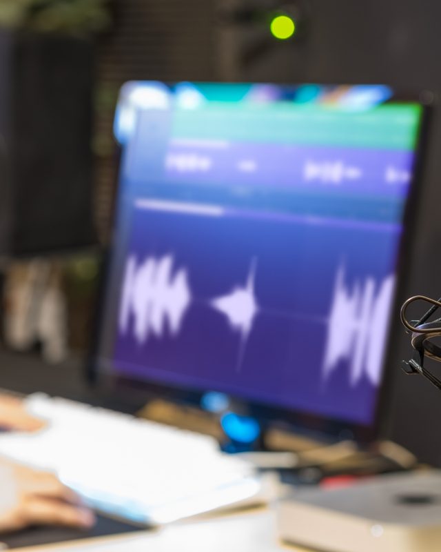 Audio engineer editing a podcast waveform, the hours behind each published episode