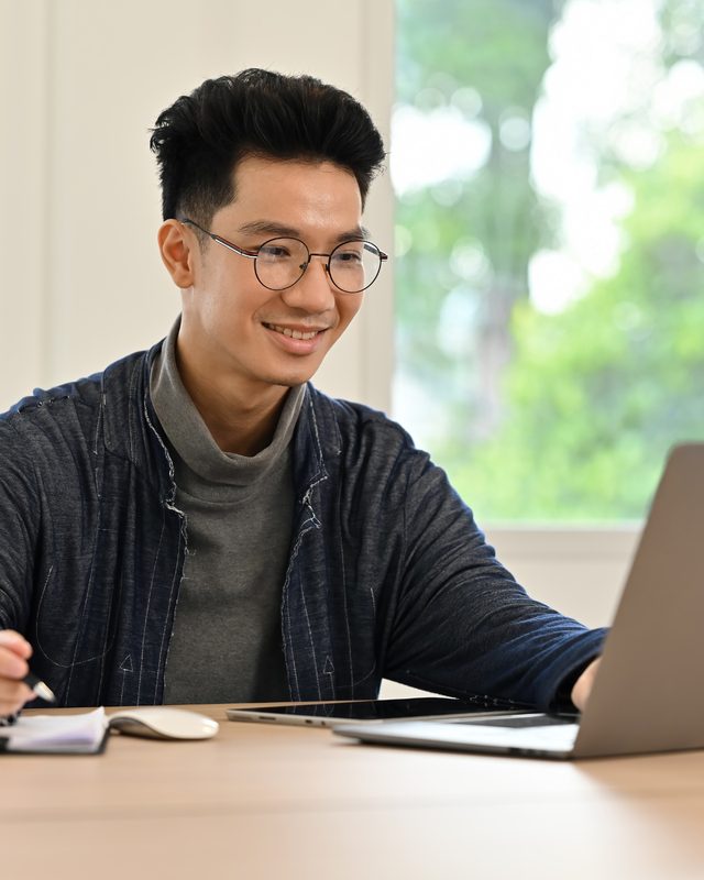 Writer researching podcast industry notes and articles at a desk