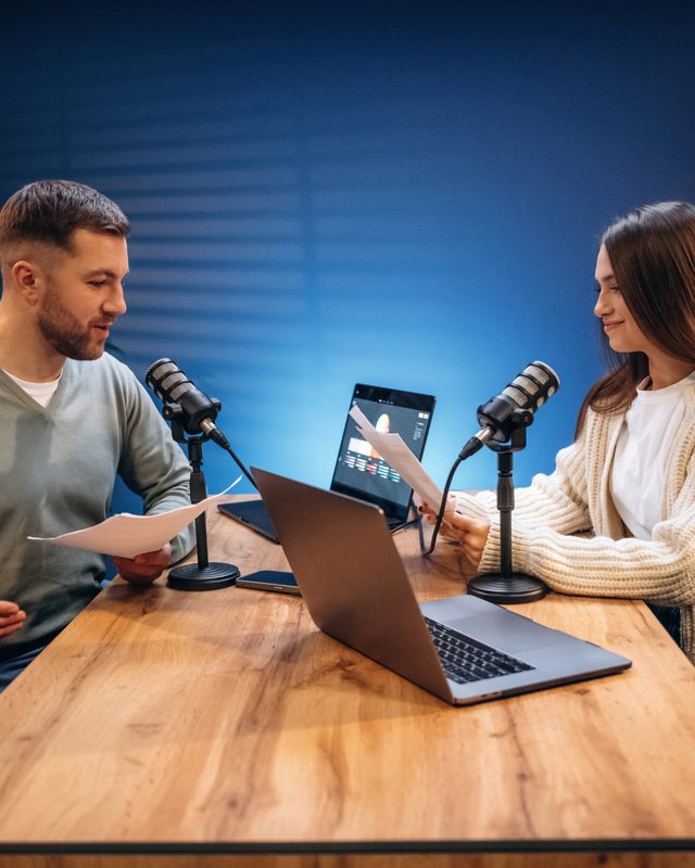 Podcast host and producer reviewing show analytics and growth data on a laptop